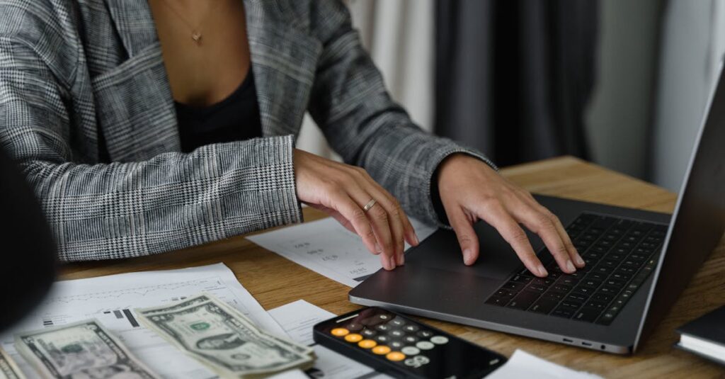 A businesswoman working on finance management with cash and calculator on desk.