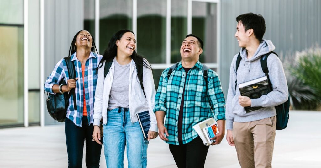 Group of diverse college students laughing and walking on campus.